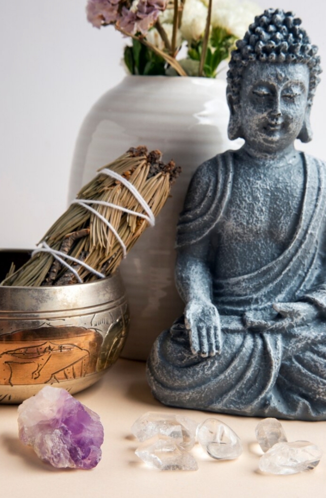 Espacio holístico de masajes terapéuticos en Flores con cuenco tibetano, velas aromáticas, estatua de buda y cuarzos